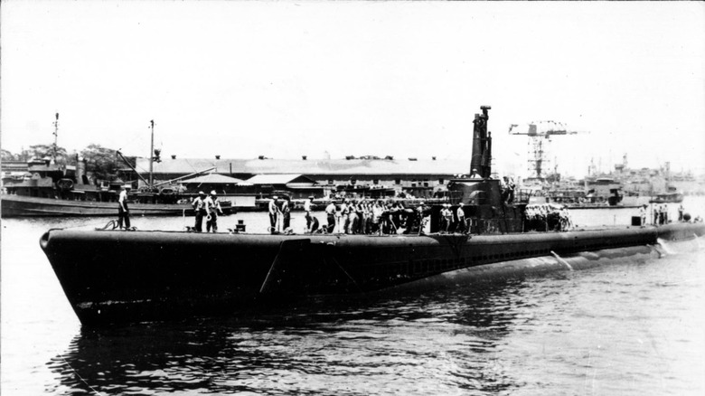 The USS Tang in port with its crew standing on its hull