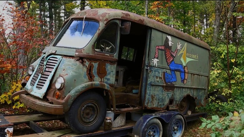 Rusty van on a trailer with an "Aerosmith" logo on the side