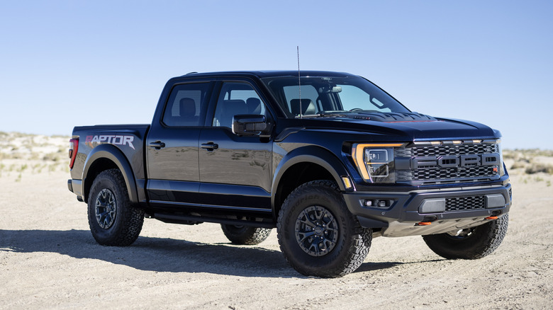 Side view of dark blue 2023 Ford 150 Raptor R on a sandy terrain