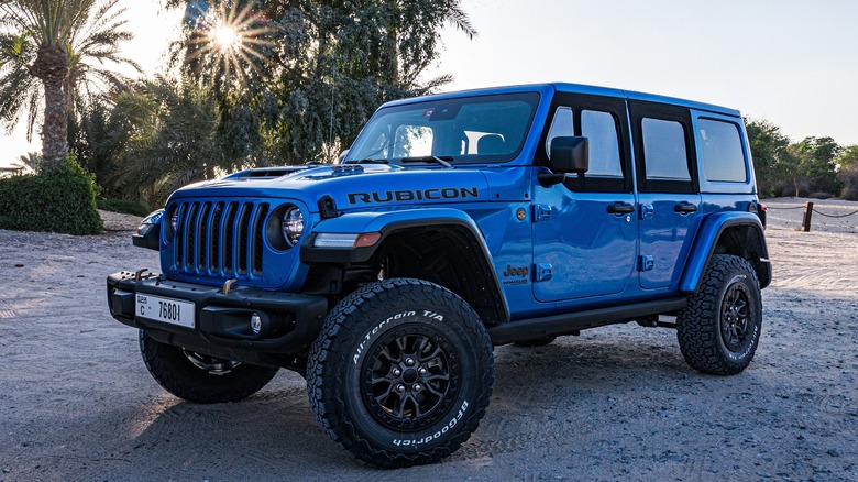 Front quarter view of blue Jeep Wrangler Rubicon parked on the beach