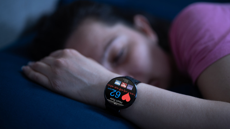 person sleeping with smartwatch heart display