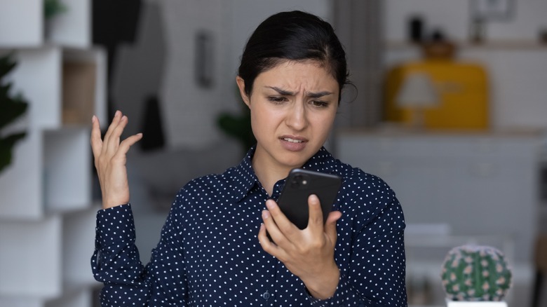 person looking frustratedly at smartphone