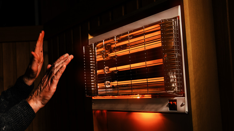 A person warming up beside a space heater