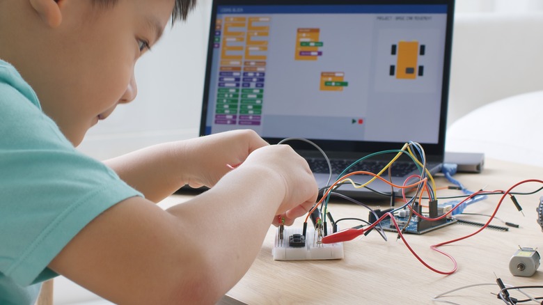 child playing with Arduino robotics car