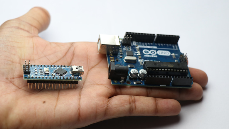 Arduino Uno next to Arduino Nano in hand