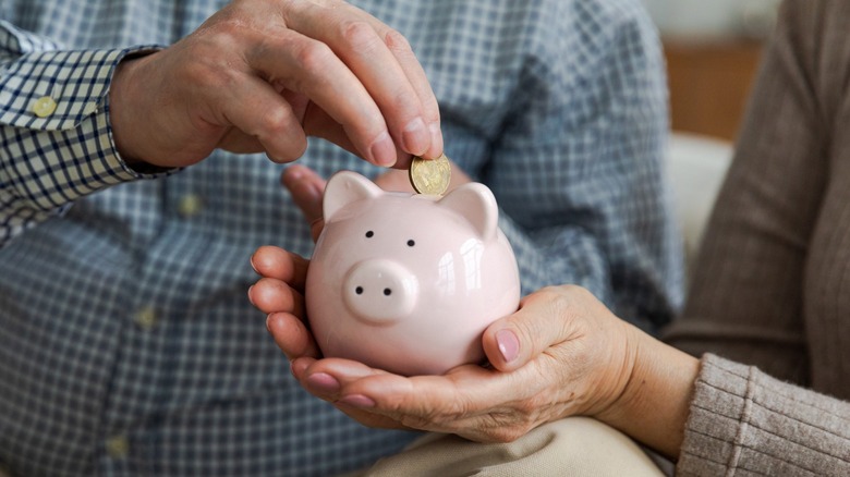 Man putting money into piggy bank