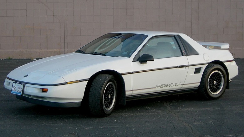 white Pontiac Fiero parked on pavement