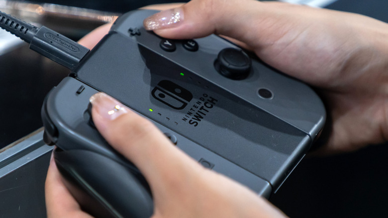 person holding Joy-Con charging grip