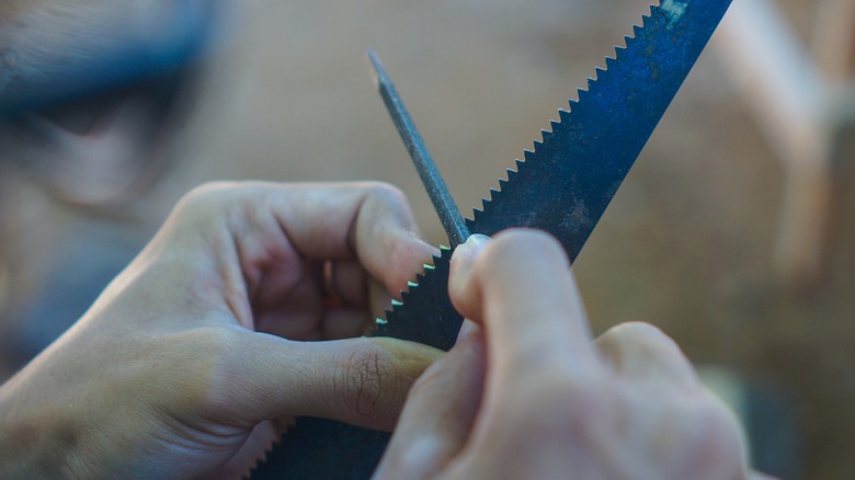 Sharpening a hand saw with a file by hand