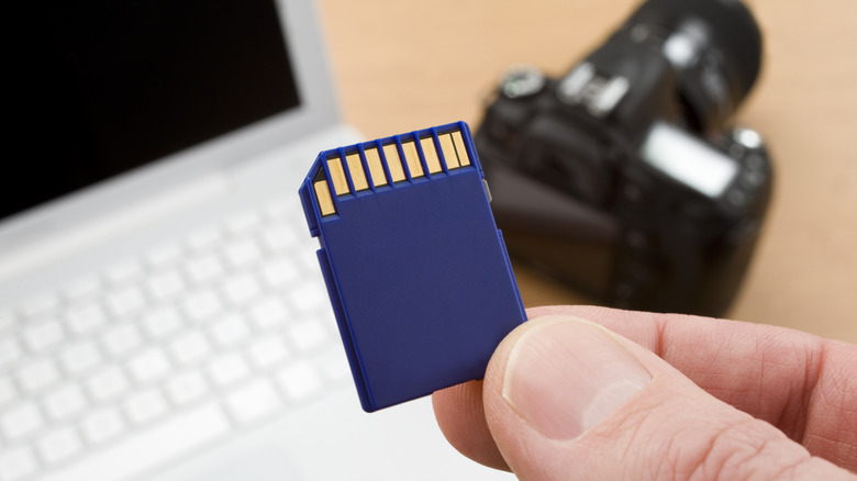 sd card with computer and camera in background