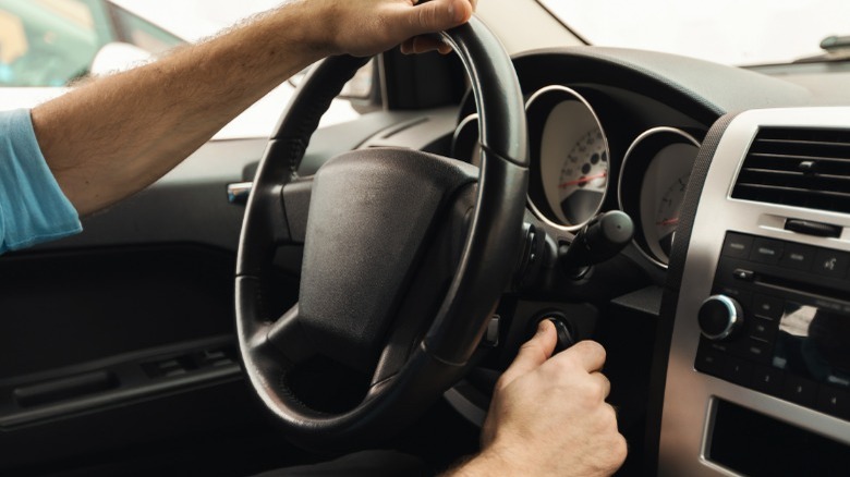 person turning car key