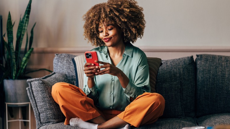 Woman on a couch holding her phone