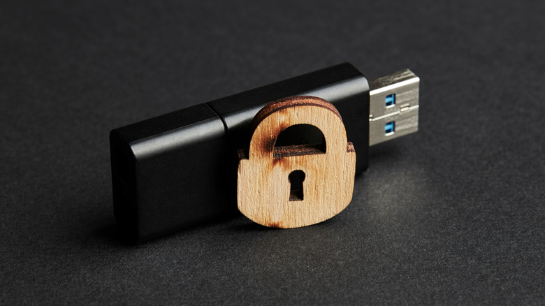 Black usb stick with wooden lock over matte background