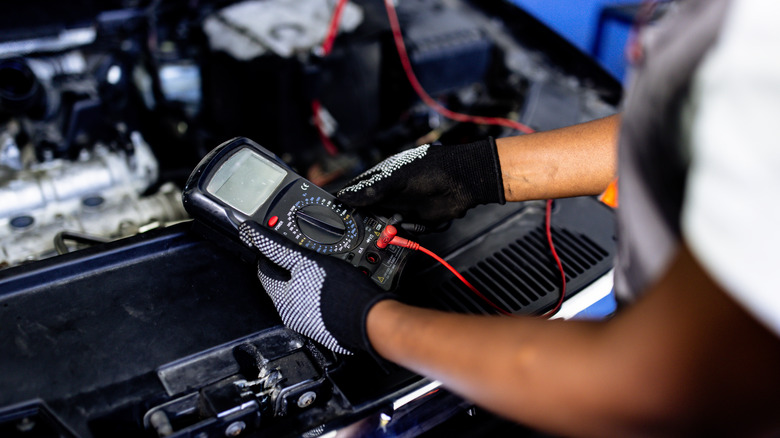 mechanic testing car battery