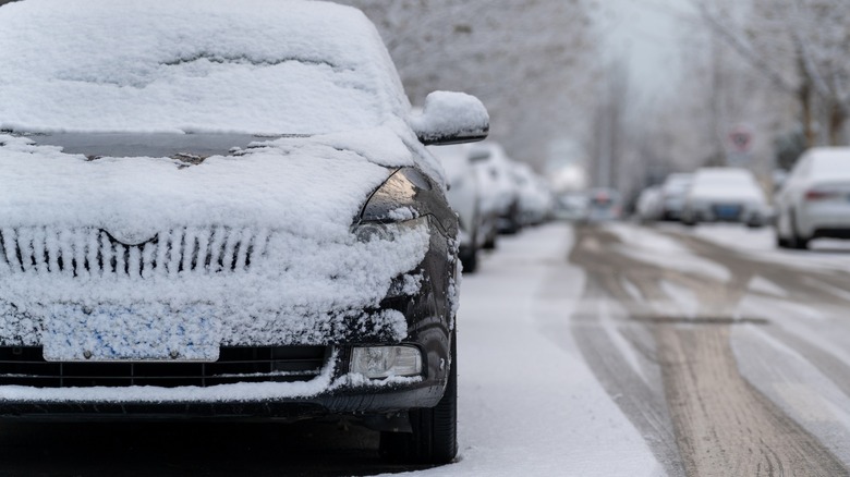 A snow covered car on the street