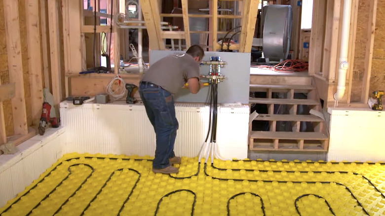 Worker installing underfloor radiant heating in a garage