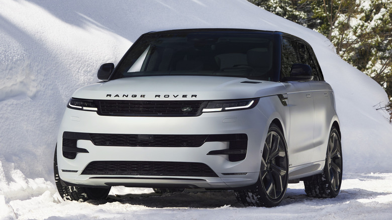 Front 3/4 view of white Land Rover Range Rover parked on snow