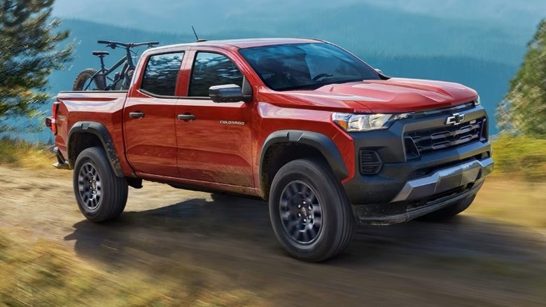 Chevrolet Colorado driving off-road with a hazy mountain range in the background