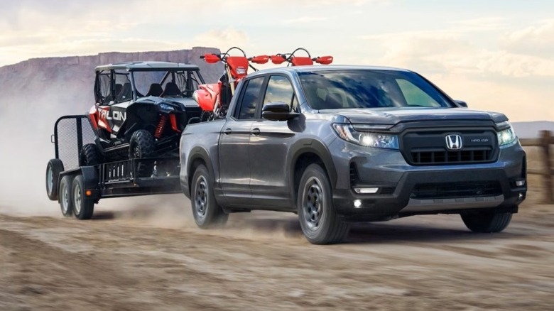 2025 Honda Ridgeline towing a loaded trailer on a dirt road