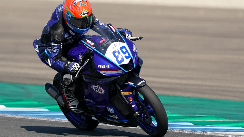 A person riding a Yamaha R3 bike on a race track