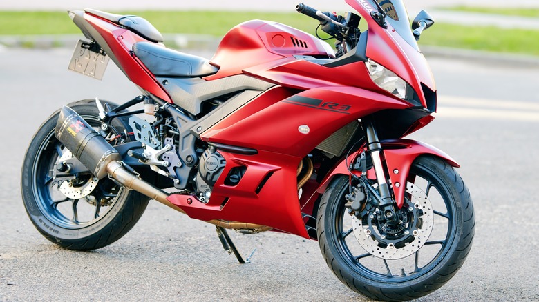 A sleek red Yamaha YZF-R3 parked in a lot