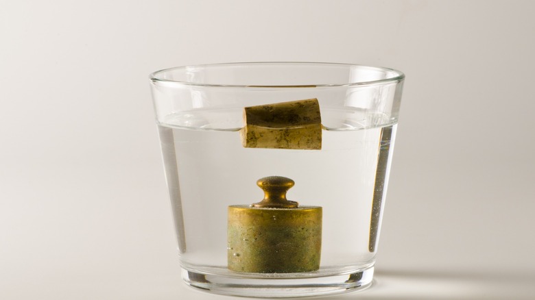 weight and cork in water glass