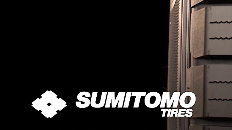 Logo for Sumitomo tires backed by tire tread