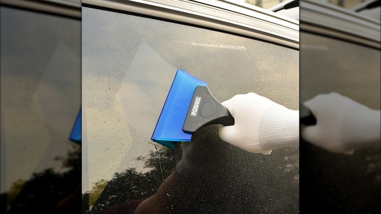 person using FOSHIO Small Squeegee to clean windshield