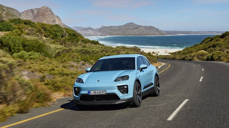 Blue Porsche Macan driving near ocean