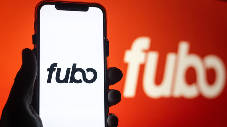 Person holding phone with fubo logo