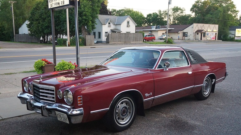 Red 1975 Dodge Charger parked in lot next to empty road