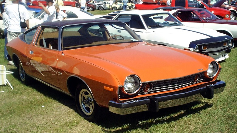 Orange 1975 AMC Matador parked in grass at car show