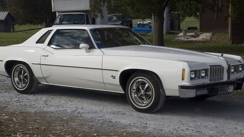 White 1977 Pontiac Grand Prix driving away from show grounds in Hershey PA