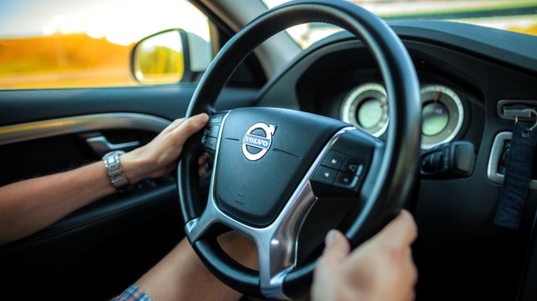 Person gripping the steering wheel of a Volvo car