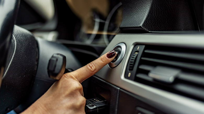 A woman pushing the start engine button