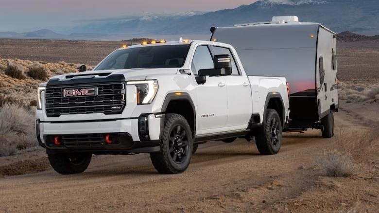 2024 GMC Sierra HD towing camper on dirt road