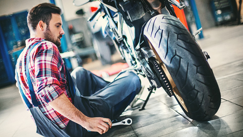 man repairing motorcycle