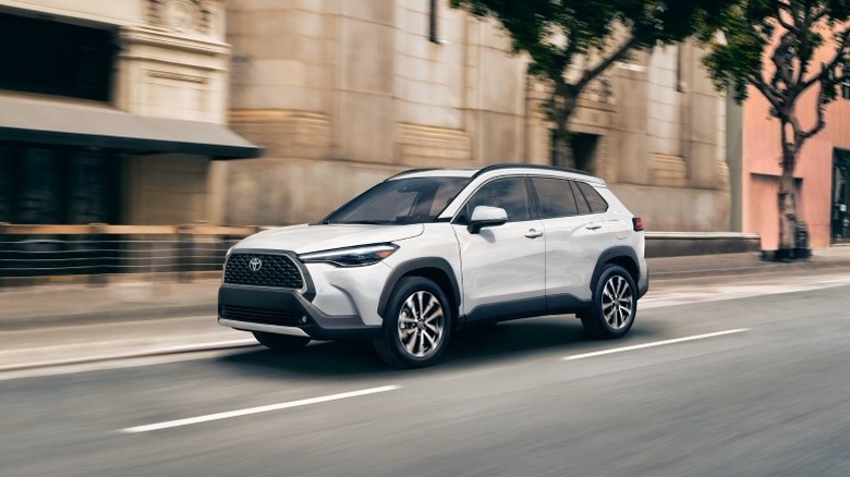 Toyota Corolla Cross Hybrid driving down a city street