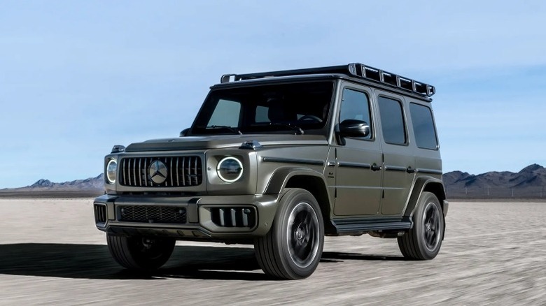 2025 Mercedes-Benz AMG G63 driving with mountains and a blue sky in the background