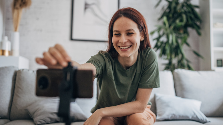 Woman angling phone on tripod