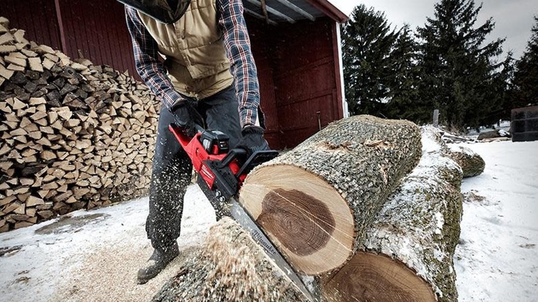 Man cutting off with a Milwaukee chainsaw