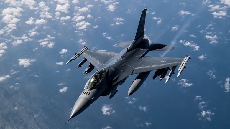 F-16 Falcon flying over scattered clouds