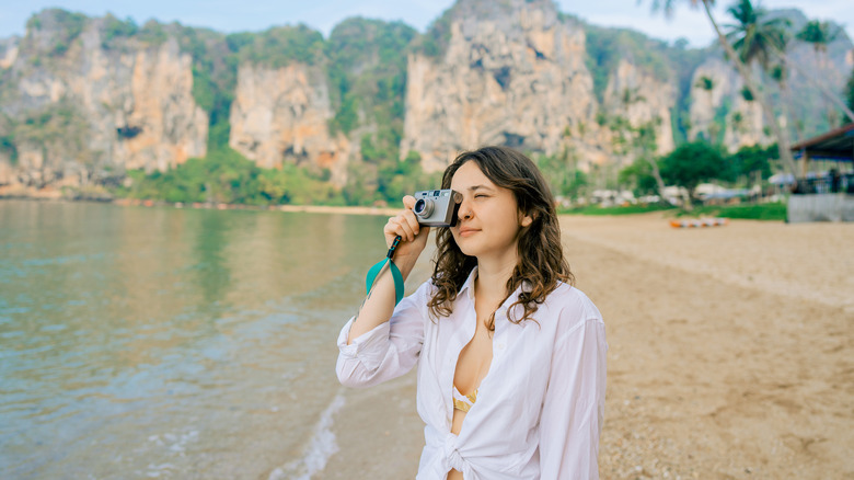 woman holding camera on beach