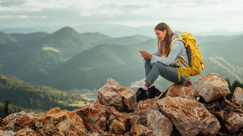 woman using phone on hike