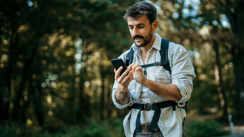 man on hike using phone