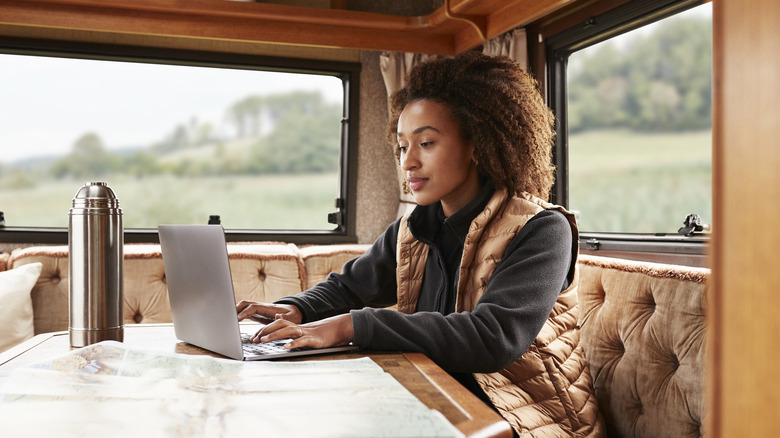 Person using a laptop in an RV.