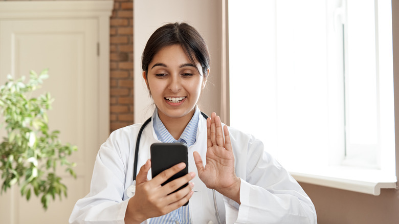 woman on a video call raising hand