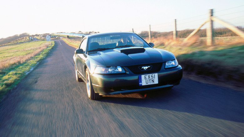 2002 Mustang driving by fields