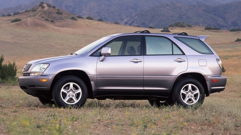 2001 Lexus RX 300 parked on grass with rolling hills and a mountain range in the background