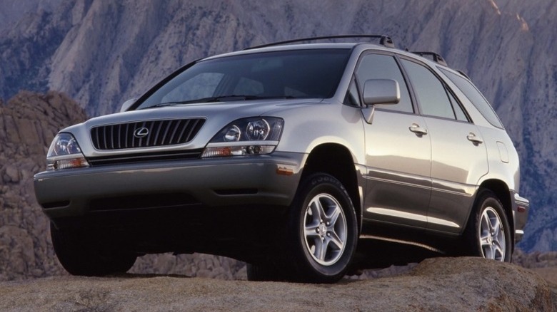 Lexus RX 300 parked on a rocky terrain with mountains in the background